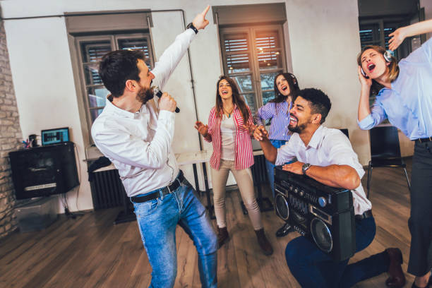 istock Business people making team training exercise during team building seminar singing karaoke. 1206489759