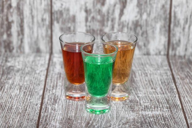 Plastic cups filled with red syrup on a blue table.