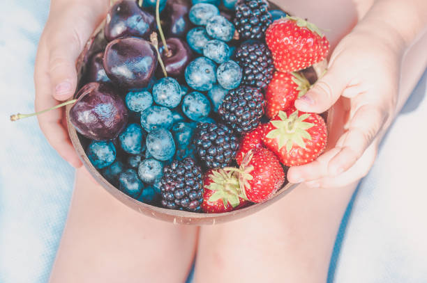 istock Girl holding a bowl with fresh berries, summer concept 1206492507