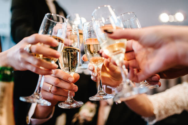 歓声！人々はトーストのためにワインを祝い、盛り上げます。シャンパンで応援する男女のグループ。 - champagne toast wine restaurant ストックフォトと画像