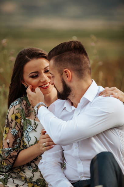 istock Young happy lovers sitting on meadow 1206495541