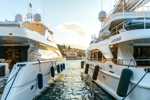 Grandes yates de lujo amarrados en el puerto de una ciudad mediterránea turística a la luz del atardecer photo