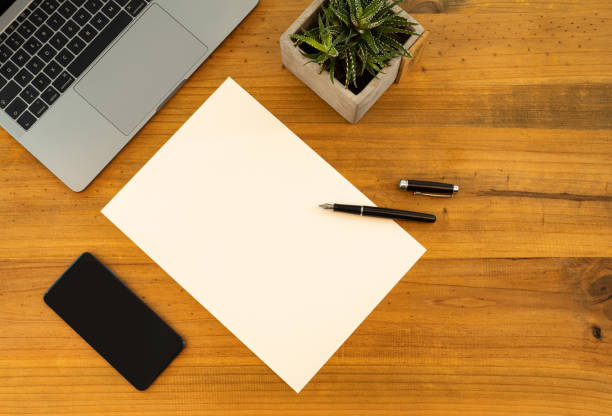 istock Table Top desk view with pencil a plant, coffee, workspace, mobile display and laptop business 1206500391