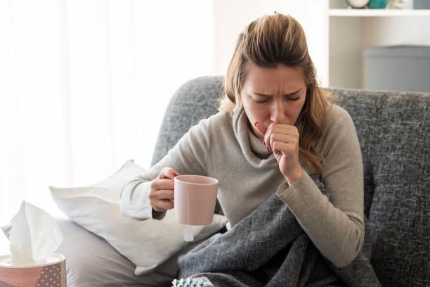 kranke frau mit grippe zu hause - husten stock-fotos und bilder