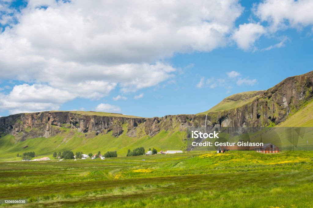 The farm and waterfall at Foss a Sidu seen from Dverghamrar basalt columns in Iceland The farm and waterfall at Foss a Sidu seen from Dverghamrar basalt columns in south Iceland Agricultural Field Stock Photo