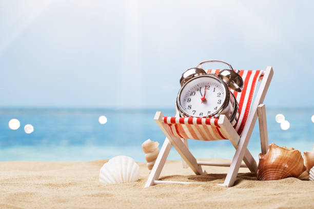 istock Alarm Clock On Deck Chair On Beach 1206507489