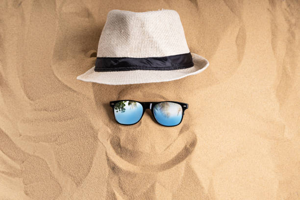 Black sunglasses on the sand surface at Pedn Vounder beach, Cornwall on an idyllic summers day.