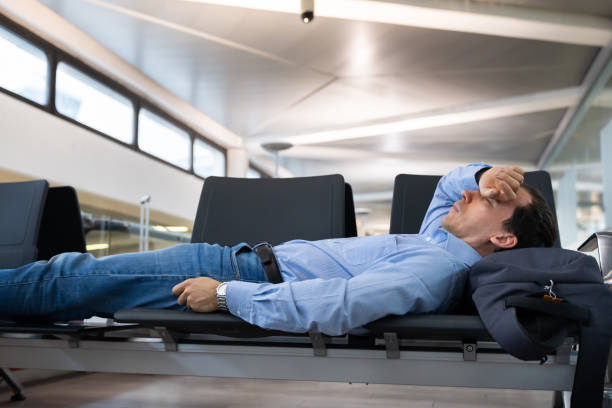 istock Man Sleeping In Airport Terminal 1206509352