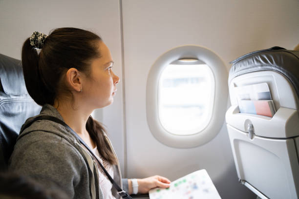 istock Woman Sitting In Airplane Looking In Window 1206509379