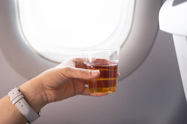 istock Hand Holding Alcohol Drink In Airplane 1206509399