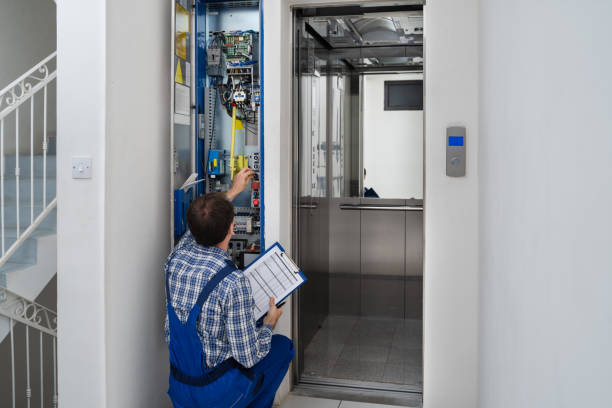 Technician Repairing Elevator Technician Repairing Control Panel Of Broken Elevator lift stock pictures, royalty-free photos & images