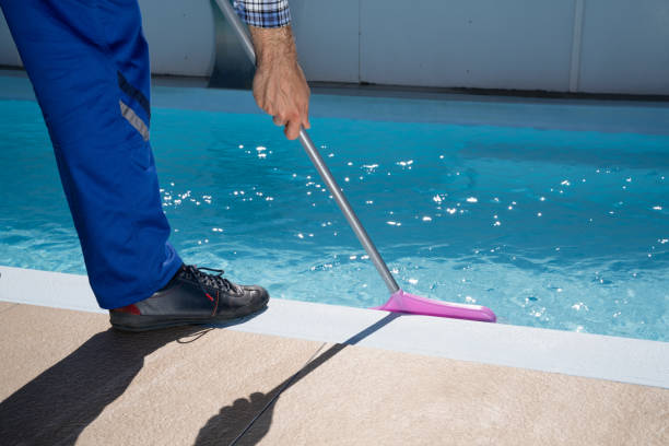 istock Male Worker In Uniform Cleaning Pool 1206509737