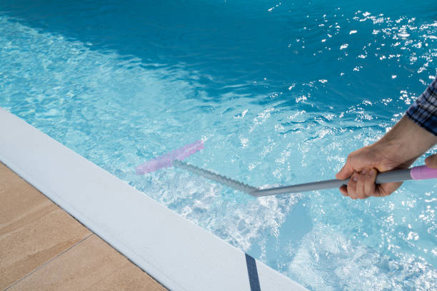 istock Male Worker In Uniform Cleaning Pool 1206509739