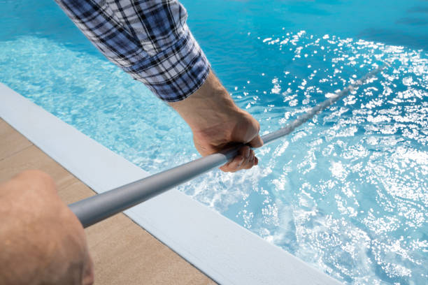 istock Male Worker In Uniform Cleaning Pool 1206509743