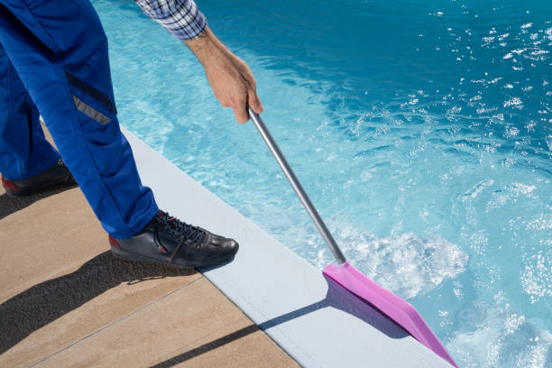 istock Male Worker In Uniform Cleaning Pool 1206509751