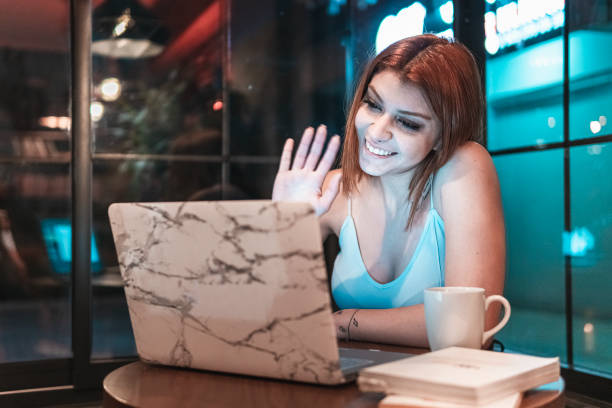 Portrait of cheerful young woman doing video call in the cafe stock photo
