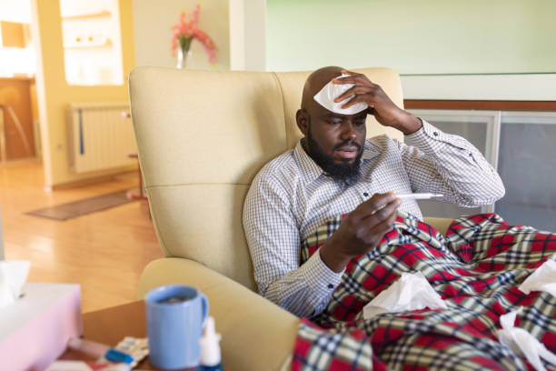 istock Ill Mature Afro-American is Checking his Temperature 1206519042