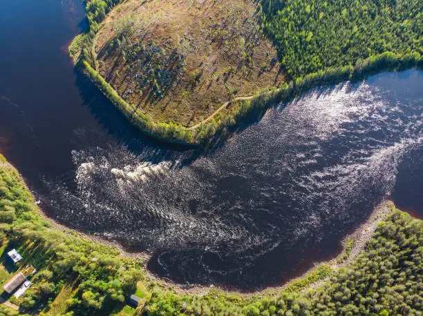 View of Kalix river, Kalixalven, Overkalix locality and the seat in Norrbotten county, Sweden, with forest in sunny summer day, aerial drone view