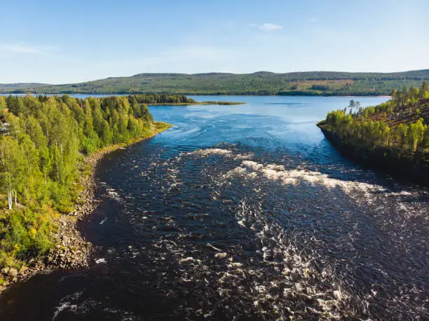 Photo of View of Kalix river, Kalixalven, Overkalix locality and the seat in Norrbotten county, Sweden, with forest in sunny summer day, aerial drone view