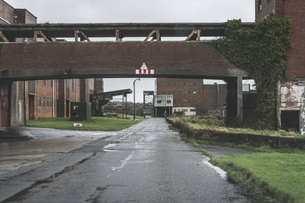 Carrickfergus, Northern Ireland, United Kingdom - February 15, 2020: a road leading through an abandoned former factory site (Courtaulds) which once specialised in the production of artificial fibres and employed over 2000 people.  It closed in 1981.