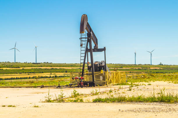 istock Old oil extraction pump with wind turbines in the background, Sp 1206524726