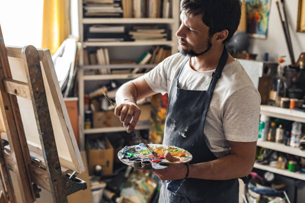 istock Male painter at art studio indoors micing colors looking at canvas pensive 1206531980