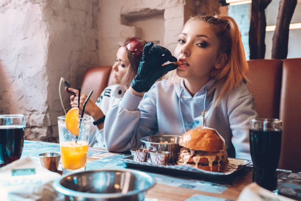 Two teenage girls sitting in cafe together