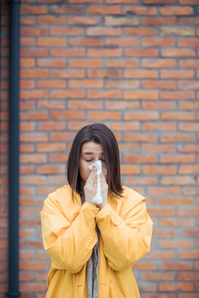 istock Sick young woman blowing her nose 1206532615