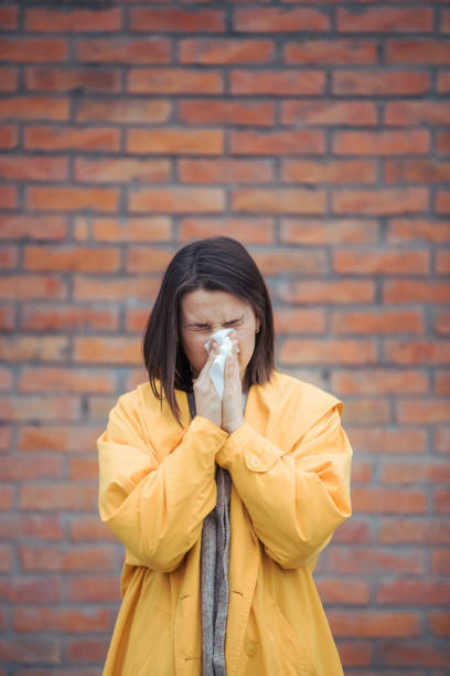 istock Sick young woman blowing her nose 1206532618