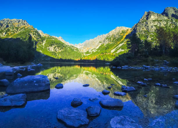 Popradske pleso lake, High Tatras Mountains, Slovakia Autumn on Popradske pleso lake in High Tatras Mountains (Vysoke Tatry), Slovakia. Picturesque panoramic evening view pleso stock pictures, royalty-free photos & images