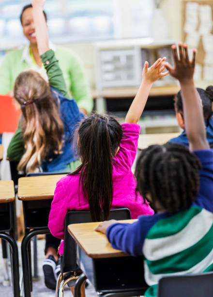istock Asian girl raising hand in elementary school classroom 1206534772