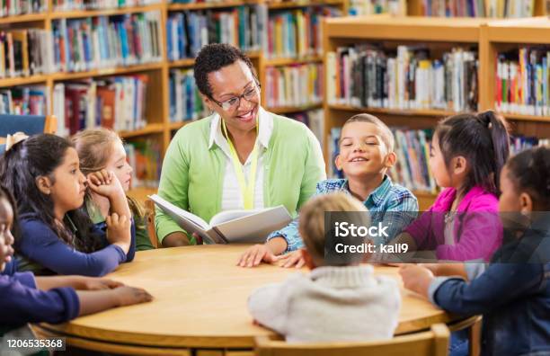 図書館で子供たちに読む教師