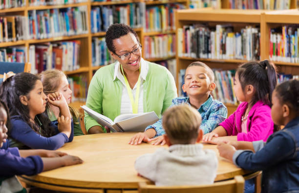 istock Teacher reading to children in library 1206535368