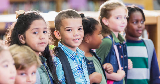istock Mixed race boy in school standing with classmates 1206535369