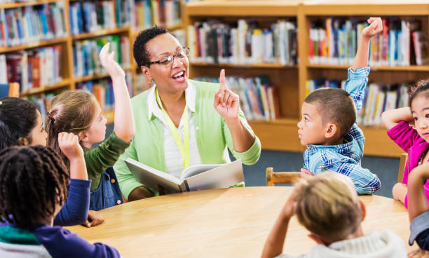 istock Teacher reading to children in library 1206535412