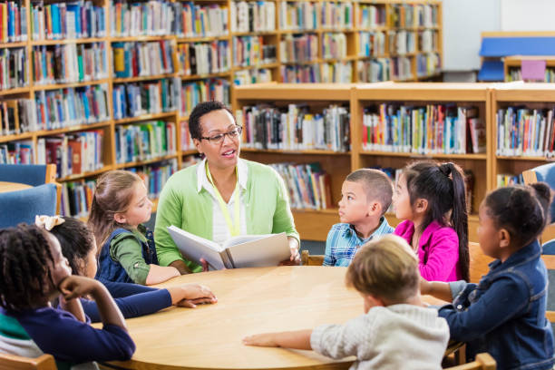 istock Teacher reading to children in library 1206535413