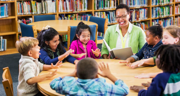 Teacher reading to children in library, playing