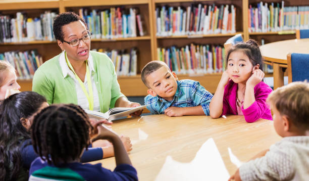 istock Teacher reading to children in library 1206535492