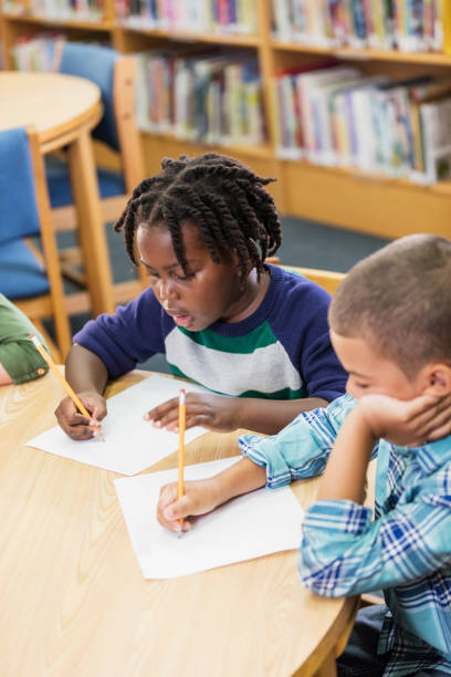 istock African-American boy and classmate writing in school 1206535602