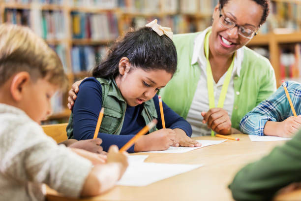 istock Hispanic girl with teacher, classmates, writing 1206535937