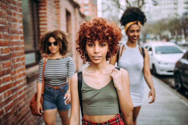 istock Three happy curly girlfriends in city 1206536577