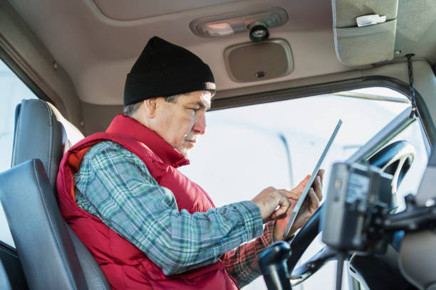 istock Senior Hispanic man driving semi-truck, using tablet 1206536735