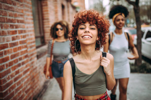 istock Three happy curly girlfriends in city 1206536771