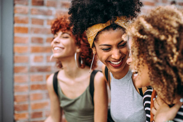 istock Three happy curly girlfriends in city 1206538157