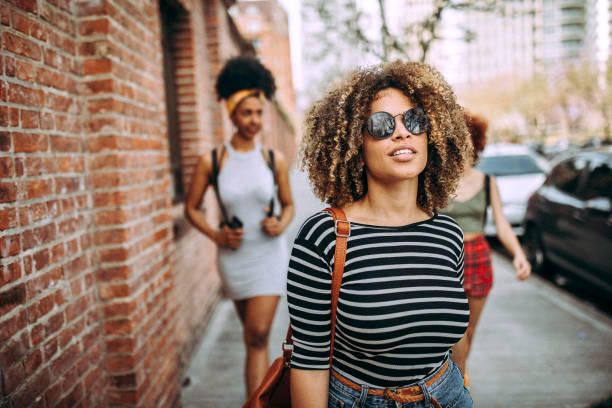 istock Three happy curly girlfriends in city 1206538240