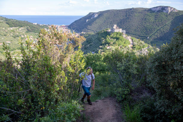 istock Young man ascends trail wearing backpack, at sunrise 1206538260