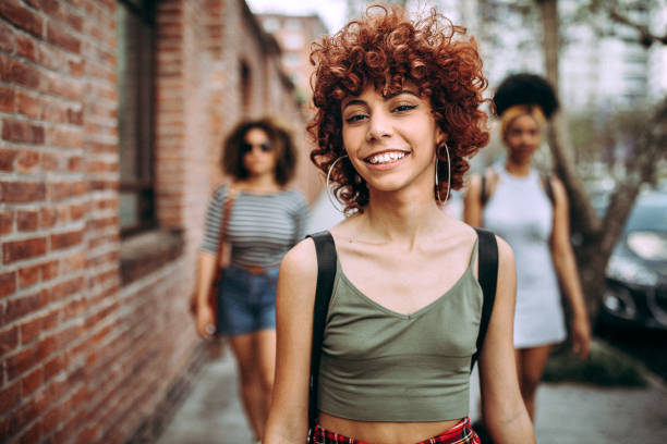 istock Three happy curly girlfriends in city 1206538502