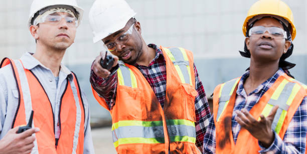 istock Three construction workers in hardhats and safety vests 1206538523