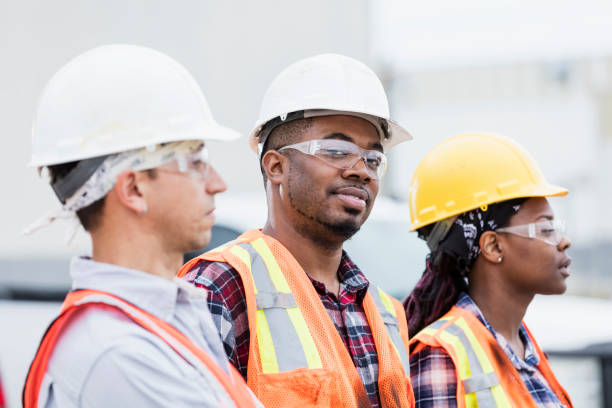 istock Three construction workers in hardhats and safety vests 1206539588