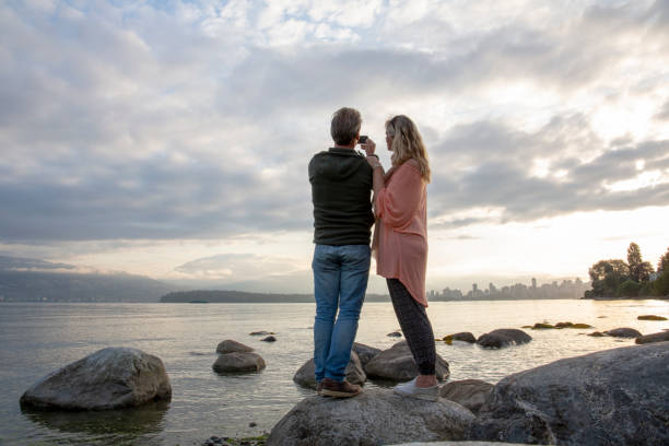 istock Mature couple relax on beach rocks at sunrise 1206540822